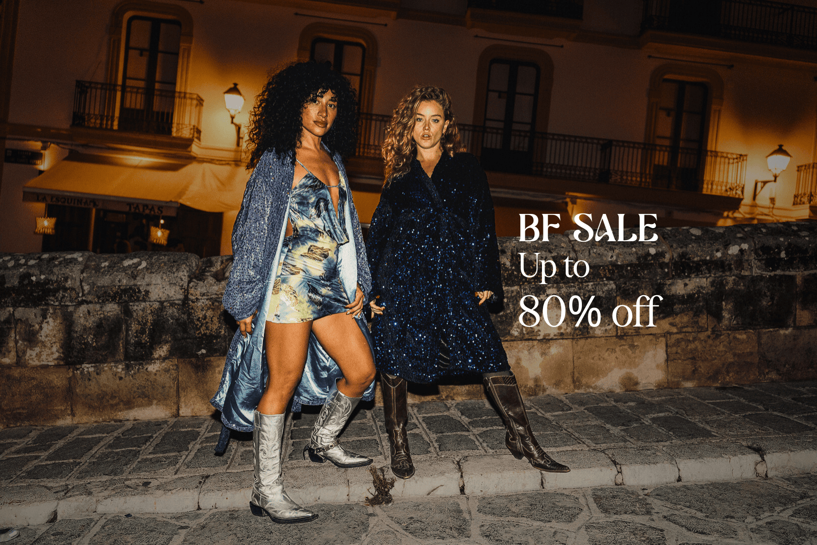 Two women standing on a street with a sale advertisement overlay.