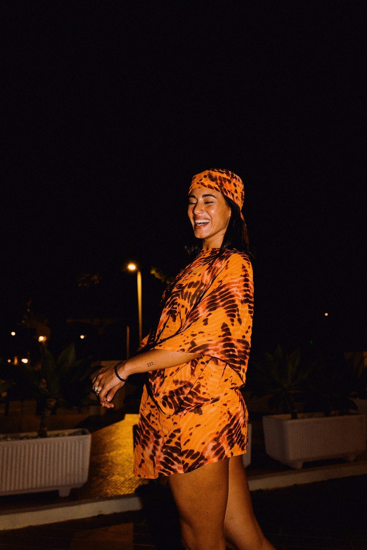 SOLARA orange tie-dye headscarf styled with matching mini dress – editorial photograph 00546