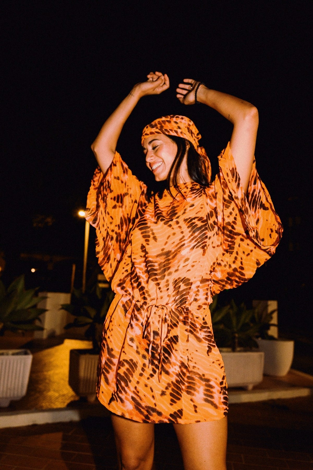 SOLARA orange tie-dye headscarf styled with matching mini dress – editorial photograph 00551