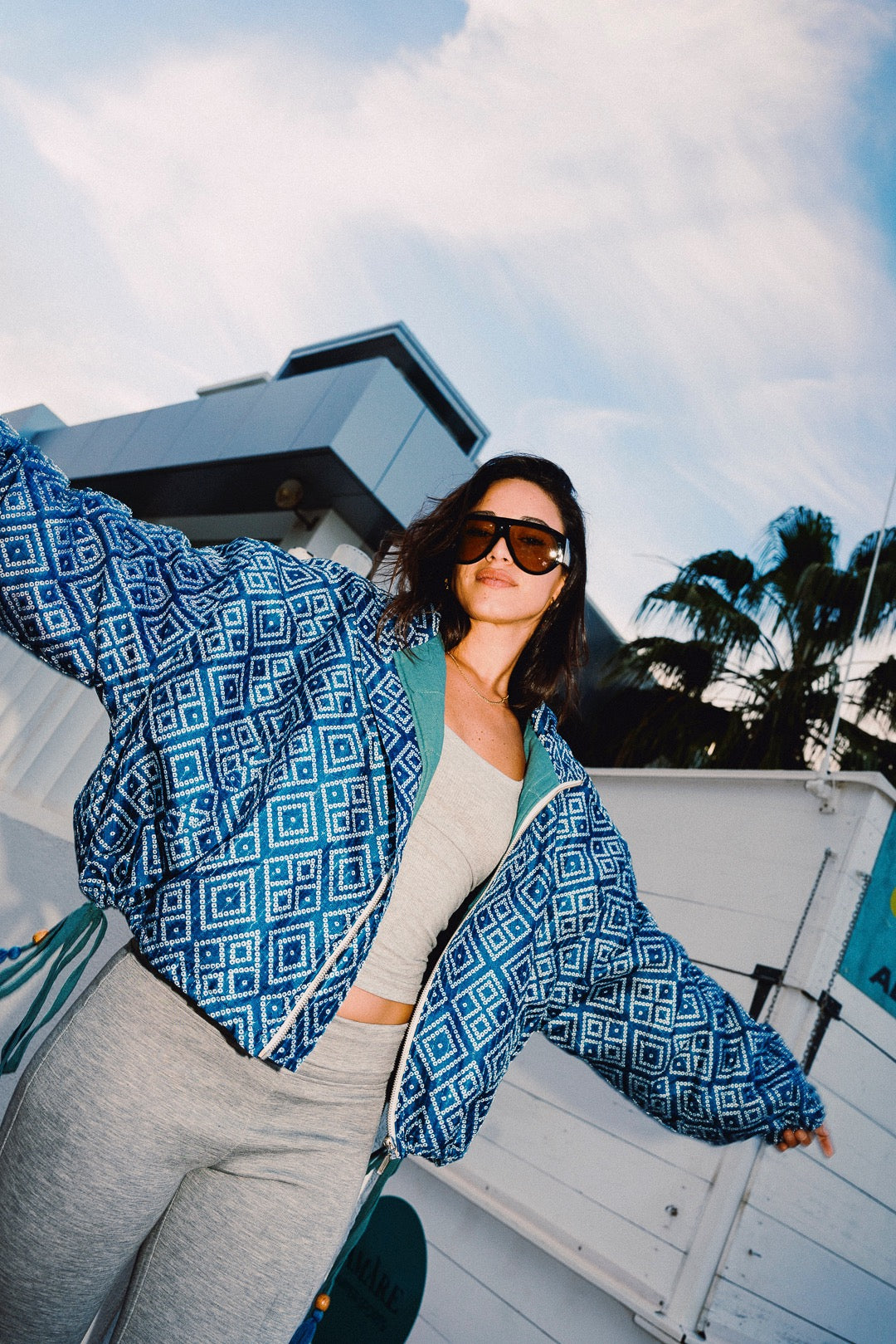 STOOP denim blue geometric bomber jacket with turquoise lining and adjustable tassel ties, model view 4