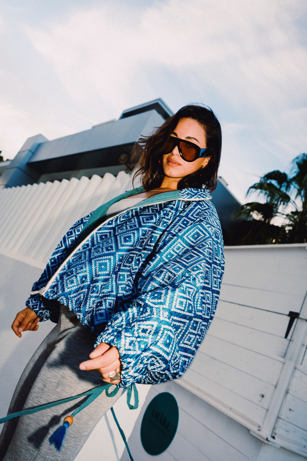 STOOP denim blue geometric bomber jacket with turquoise lining and adjustable tassel ties, model view 5