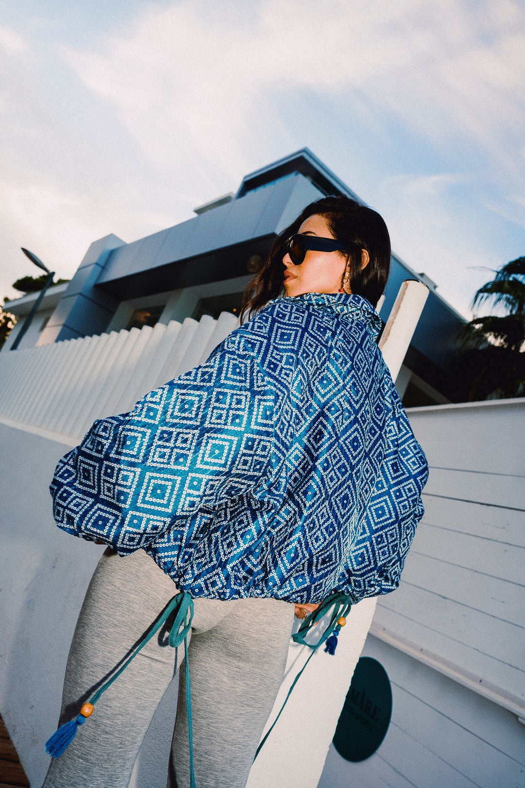 STOOP denim blue geometric bomber jacket with turquoise lining and adjustable tassel ties, model view 6