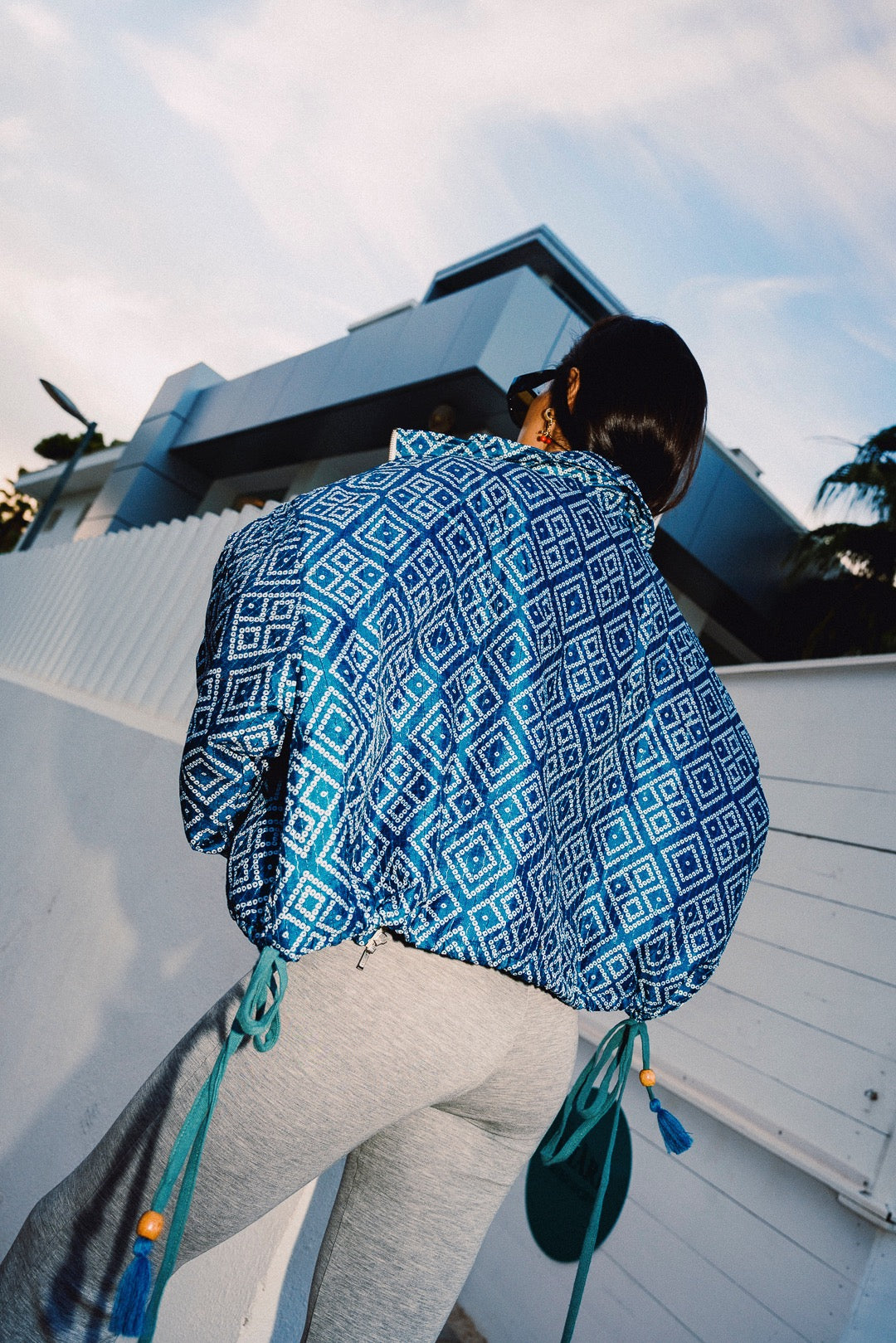 STOOP denim blue geometric bomber jacket with turquoise lining and adjustable tassel ties, model view 7
