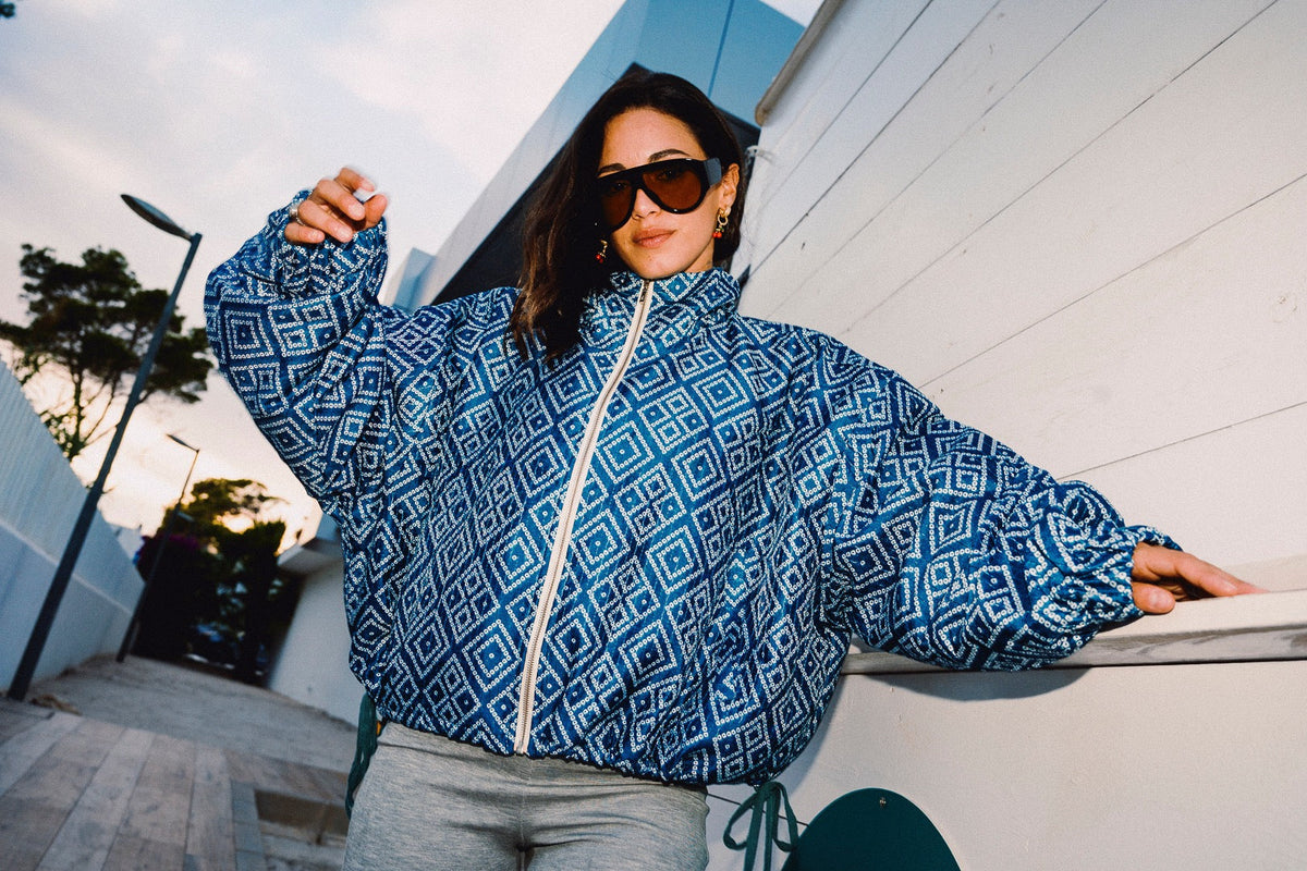 STOOP denim blue geometric bomber jacket with turquoise lining and adjustable tassel ties, model view 12